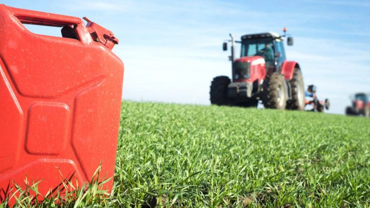 Bidón de combustible en un campo, con un tractor de fondo